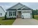 Charming single-story home featuring a gray facade, a two-car garage, and manicured landscaping at 130 W Saltgrass Ln, Smithfield, NC 27577