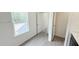 Bright bathroom featuring modern gray vinyl flooring, a large window, and an open doorway to the hall at 140 Gobbler Dr, Smithfield, NC 27577