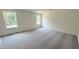 Bright bedroom featuring neutral walls, plush carpeting, and two windows providing ample natural light at 140 Gobbler Dr, Smithfield, NC 27577