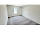 Carpeted bedroom features a window providing natural light and a view of the neighborhood at 140 Gobbler Dr, Smithfield, NC 27577