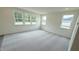 Bright living room featuring neutral walls, carpet flooring, and ample natural light from multiple windows at 140 Gobbler Dr, Smithfield, NC 27577