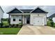 Charming single-story home with a white garage, black trim, a welcoming entrance, and a well-manicured lawn at 140 W Saltgrass Ln, Smithfield, NC 27577