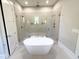 Luxury bathroom featuring a soaking tub, glass shower, and tile flooring at 1405 Song Bird Crest Way, Raleigh, NC 27613