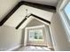 Bedroom with vaulted ceiling with wood beams and a large window at 1405 Song Bird Crest Way, Raleigh, NC 27613