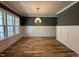 Dining room featuring hardwood floors, wainscoting, a modern chandelier and ample natural light at 1405 Song Bird Crest Way, Raleigh, NC 27613