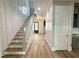 Bright foyer featuring hardwood floors, paneled walls, and a staircase leading to the upper level at 1405 Song Bird Crest Way, Raleigh, NC 27613
