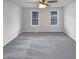 Empty bedroom featuring gray carpet, a ceiling fan with lighting, and two large windows to provide light at 143 George Wilton Dr, Clayton, NC 27520