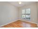 A bedroom features hardwood floors and a window with blinds that allows natural light to come in at 144 Sabiston Ct, Cary, NC 27519