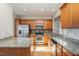 Modern kitchen featuring granite countertops, stainless steel appliances, and wood cabinets at 144 Sabiston Ct, Cary, NC 27519