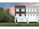 Charming townhouse showcasing a modern design and inviting entrance, set against a picturesque sunset backdrop at 1475 Hasse Ave, Apex, NC 27502