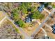 Aerial view of a house with solar panels on the roof, surrounded by trees and well-manicured landscaping at 153 Dell Meadows Pl, Four Oaks, NC 27524
