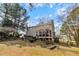 Wide backyard showcasing mature trees, a deck and hot tub, a screened-in porch, and a privacy fence at 153 Dell Meadows Pl, Four Oaks, NC 27524