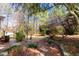 Landscaped backyard with a stone pathway, mature trees and shrubs, and a shed at 153 Dell Meadows Pl, Four Oaks, NC 27524