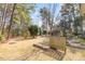 The backyard features a large grassy area, mature trees, and defined garden beds at 153 Dell Meadows Pl, Four Oaks, NC 27524