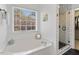 Bright bathroom with a soaking tub under a window and a glass-enclosed shower with white subway tile at 153 Dell Meadows Pl, Four Oaks, NC 27524