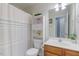 Well-lit bathroom features white cabinets, a shower with curtain, and wood-look vanity at 153 Dell Meadows Pl, Four Oaks, NC 27524