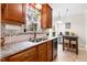 Bright kitchen featuring granite countertops, wooden cabinetry, and a view to the dining area for convenience at 153 Dell Meadows Pl, Four Oaks, NC 27524