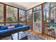 Relaxing sunroom with wood frame and view of the nature; furnished with sofa, table and area rug at 153 Dell Meadows Pl, Four Oaks, NC 27524