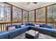 Inviting sunroom featuring wicker furniture with blue cushions, an area rug, and views of the wooded area at 153 Dell Meadows Pl, Four Oaks, NC 27524