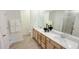 Bright bathroom with double sinks, quartz countertops, wood-look floors, and a large mirror, offering a luxurious feel at 158 Gobbler Dr, Smithfield, NC 27577