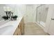 Bright bathroom with double sinks, quartz countertops, wood-look floors, and a glass enclosed shower, offering a modern feel at 158 Gobbler Dr, Smithfield, NC 27577