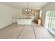 Bright kitchen area with unfinished cabinets, an island, a modern chandelier, and a sliding glass door at 158 Gobbler Dr, Smithfield, NC 27577