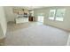 Sunlit open concept living area with wood flooring, new carpet, and stainless steel appliances at 158 Gobbler Dr, Smithfield, NC 27577