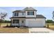 New two-story home featuring white siding, black shutters, and an attached two-car garage at 189 W Saltgrass Ln, Smithfield, NC 27577