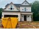 New construction home featuring black roof, framed windows, and attached garage awaiting final finishes at 197 W Saltgrass Ln, Smithfield, NC 27577