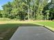 View of a well maintained lawn extending out to a lush green tree line from concrete patio at 201 W Saltgrass Ln, Smithfield, NC 27577