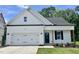 Charming single-Gathering home featuring a two-car garage, dark shutters and door, and a well-manicured lawn at 201 W Saltgrass Ln, Smithfield, NC 27577