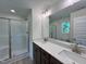 Bathroom featuring a double sink vanity with a white countertop, framed mirror, and a glass enclosed shower at 211 W Saltgrass Ln, Smithfield, NC 27577