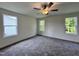 Bedroom featuring neutral walls, plush carpeting, a ceiling fan and several windows offering natural light at 211 W Saltgrass Ln, Smithfield, NC 27577