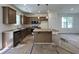 New kitchen featuring an island with stone countertops, a microwave, and updated appliances at 211 W Saltgrass Ln, Smithfield, NC 27577