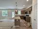 New kitchen featuring an island with stone countertops, a microwave, and updated appliances at 211 W Saltgrass Ln, Smithfield, NC 27577