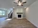 Open living area with wood floors, a fireplace, built in shelving, stairs to second floor and a ceiling fan at 211 W Saltgrass Ln, Smithfield, NC 27577