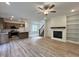 Open concept space with a kitchen, dining, living area with fireplace, ceiling fan, and access to the upstairs at 211 W Saltgrass Ln, Smithfield, NC 27577