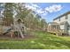 Large backyard featuring a playset, mature trees, and ample space for outdoor activities at 215 Strolling Way, Durham, NC 27707