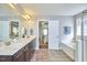 Bright bathroom with soaking tub, glass enclosed shower, and double sink vanity at 215 Strolling Way, Durham, NC 27707