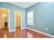 Light-filled bedroom with wood floors, a window, and a view into the closet and bathroom at 215 Strolling Way, Durham, NC 27707