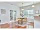 A well-lit dining area features hardwood floors, a wooden table with four chairs, and a sliding glass door to the patio at 215 Strolling Way, Durham, NC 27707