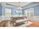 Elegant dining room boasting wainscoting, wood floors, stylish lighting, and a large window at 215 Strolling Way, Durham, NC 27707