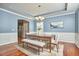 Charming dining room showcasing wainscoting, tray ceilings, wood floors, and natural light at 215 Strolling Way, Durham, NC 27707
