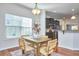A charming dining area showcases a wooden table, chairs, and an open layout adjoining the kitchen, perfect for entertaining at 215 Strolling Way, Durham, NC 27707