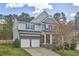 Charming two-story home with a stone and siding exterior, featuring a manicured lawn and a two-car garage at 215 Strolling Way, Durham, NC 27707