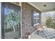 Close-up of the front porch featuring a wreath, seating, and stone detailing at 215 Strolling Way, Durham, NC 27707