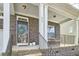 Inviting front porch with stone accents, a seating area, and a decorative wreath on the door at 215 Strolling Way, Durham, NC 27707