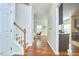 Hallway view with stairs, hardwood floors, neutral walls, and access to the kitchen and living area at 215 Strolling Way, Durham, NC 27707