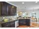 Spacious kitchen featuring dark cabinets, tile backsplash, stainless appliances, and eat-in counter at 215 Strolling Way, Durham, NC 27707