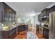Well-equipped kitchen with dark cabinetry, granite countertops, stainless steel appliances, and open layout at 215 Strolling Way, Durham, NC 27707
